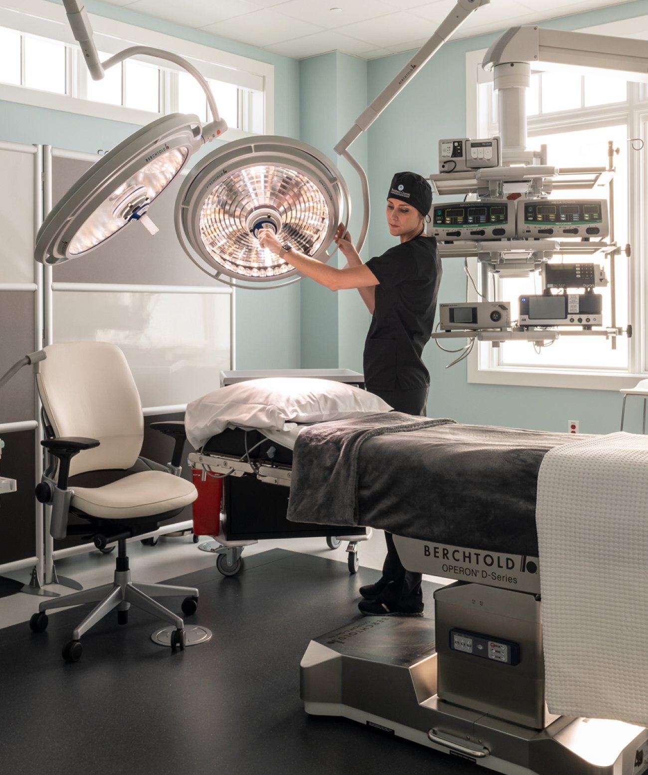 A nurse/team member setting a room up for a procedure.